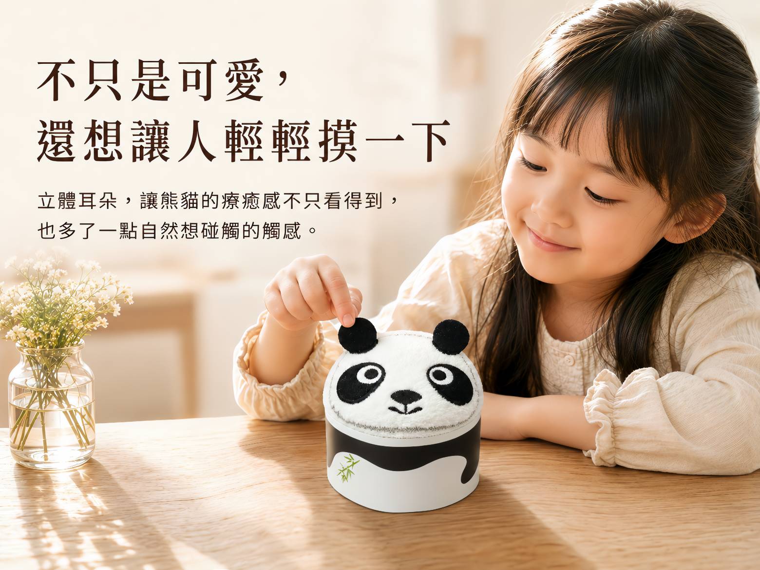小女孩輕輕觸摸熊貓造型毛巾的立體耳朵